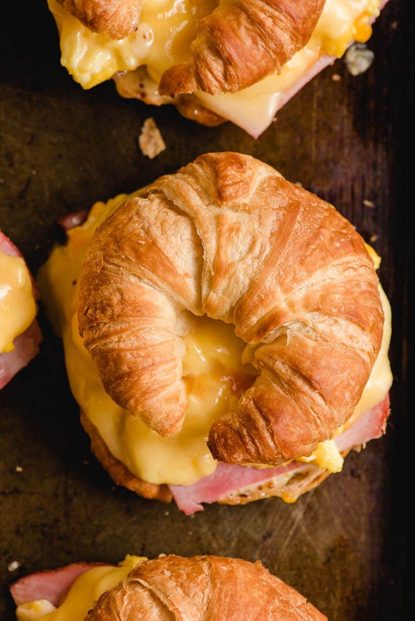 croissant breakfast sandwich on a dark baking sheet