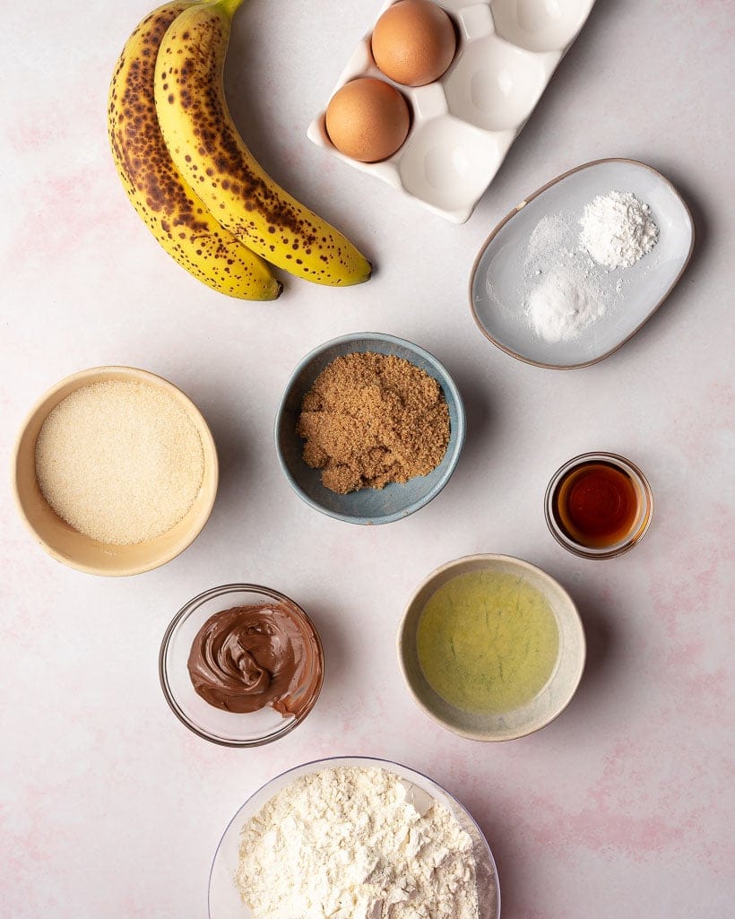 ingredients for muffins including bananas, sugars, flour, vanilla, eggs, and nutella
