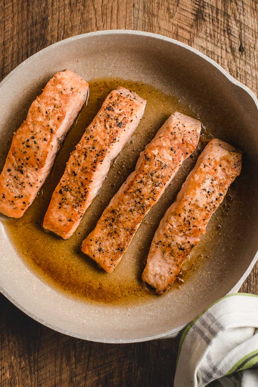 pan full of seared salmon fillets