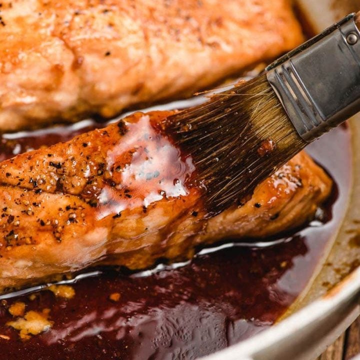brush brushing honey soy glaze on salmon fillet