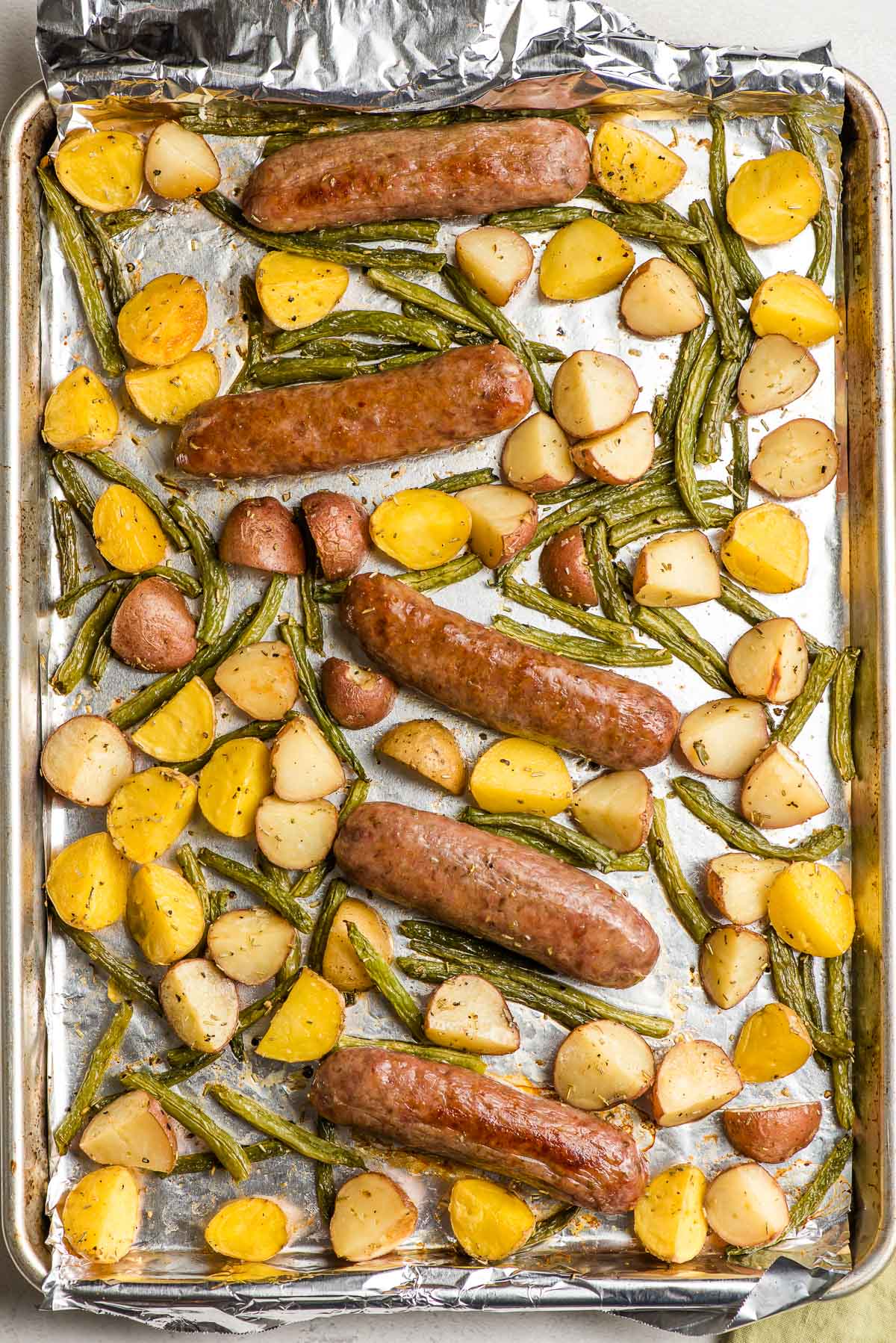 Roasted Italian Sausage, potatoes, and green beans on a sheet pan.