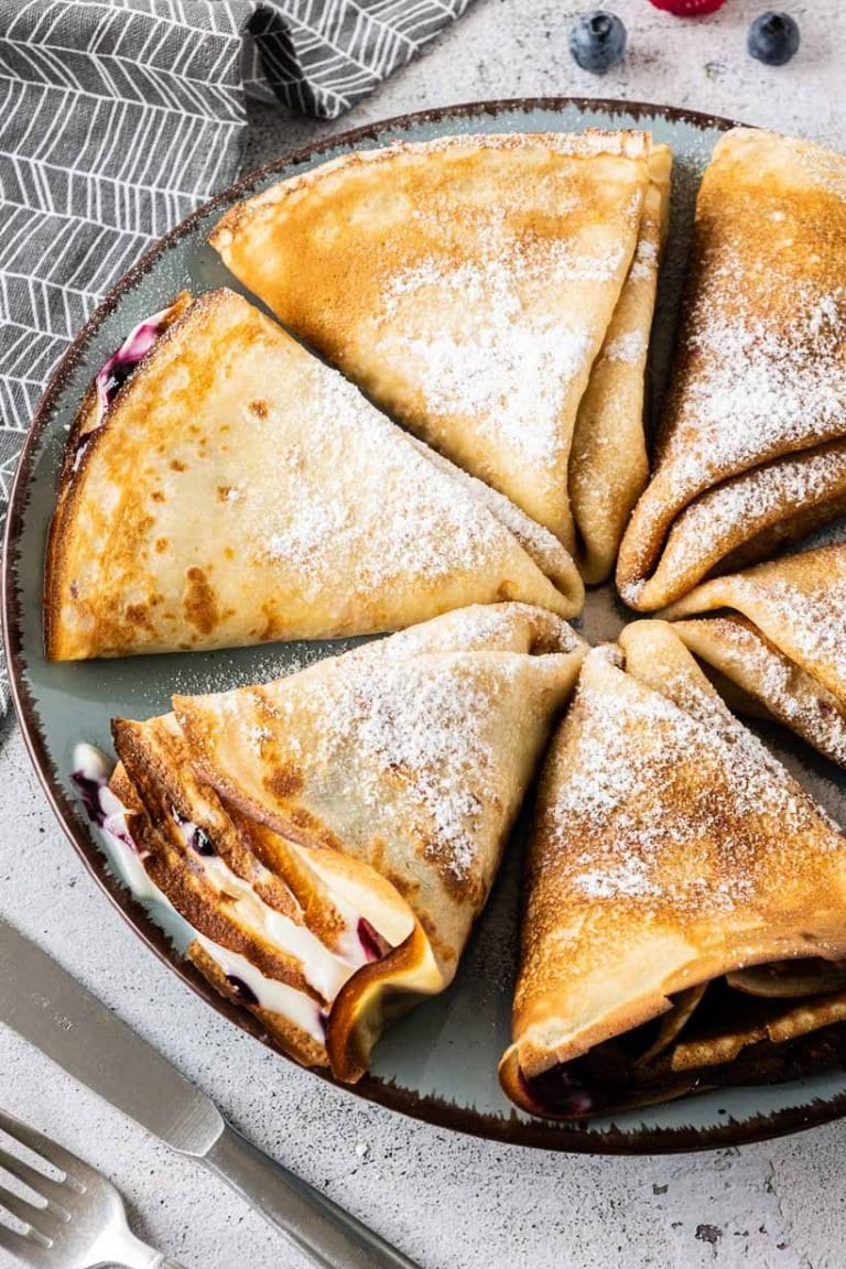 Multiple crepes folded on a blue plate.