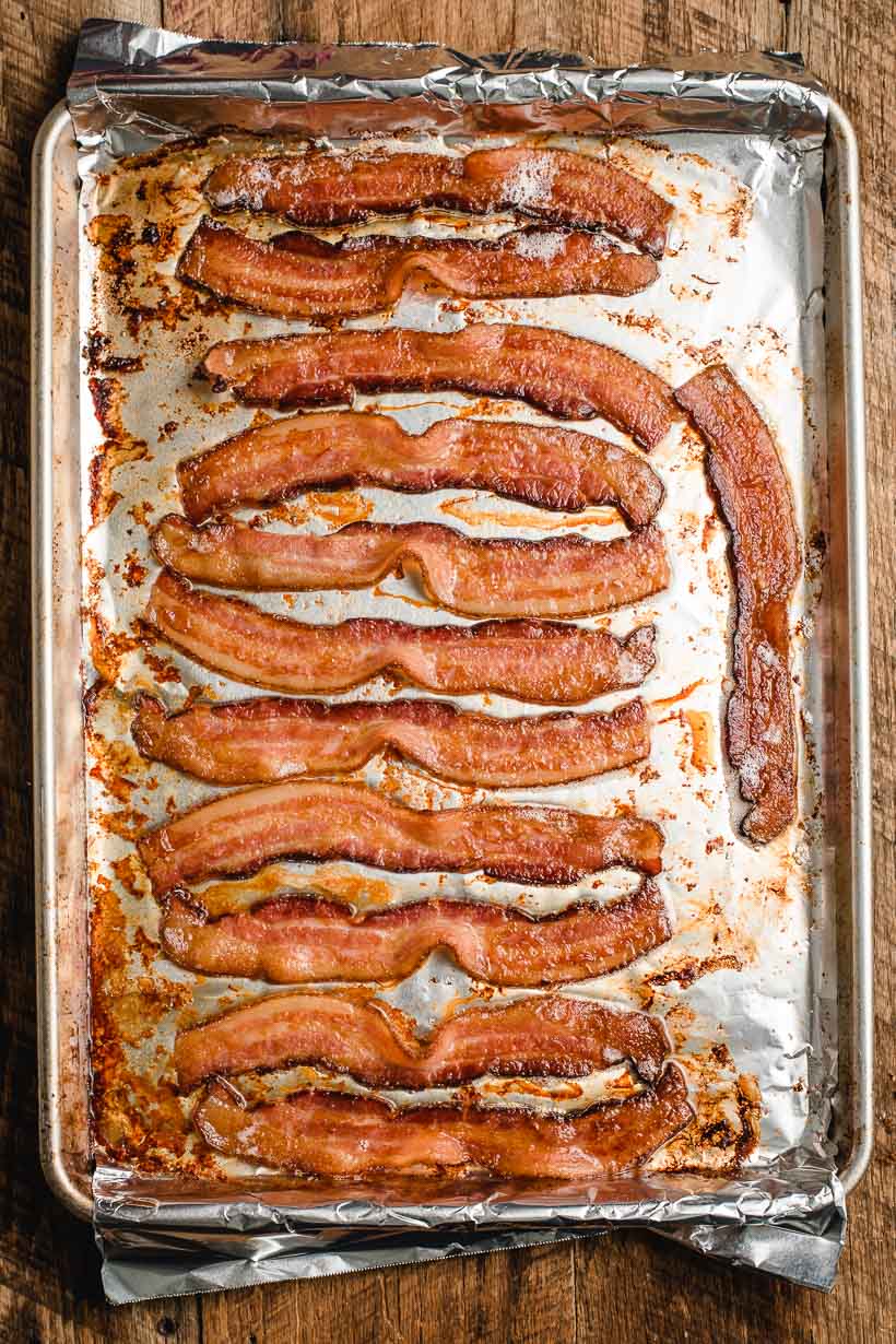 Baking sheet full of slices of baked bacon.