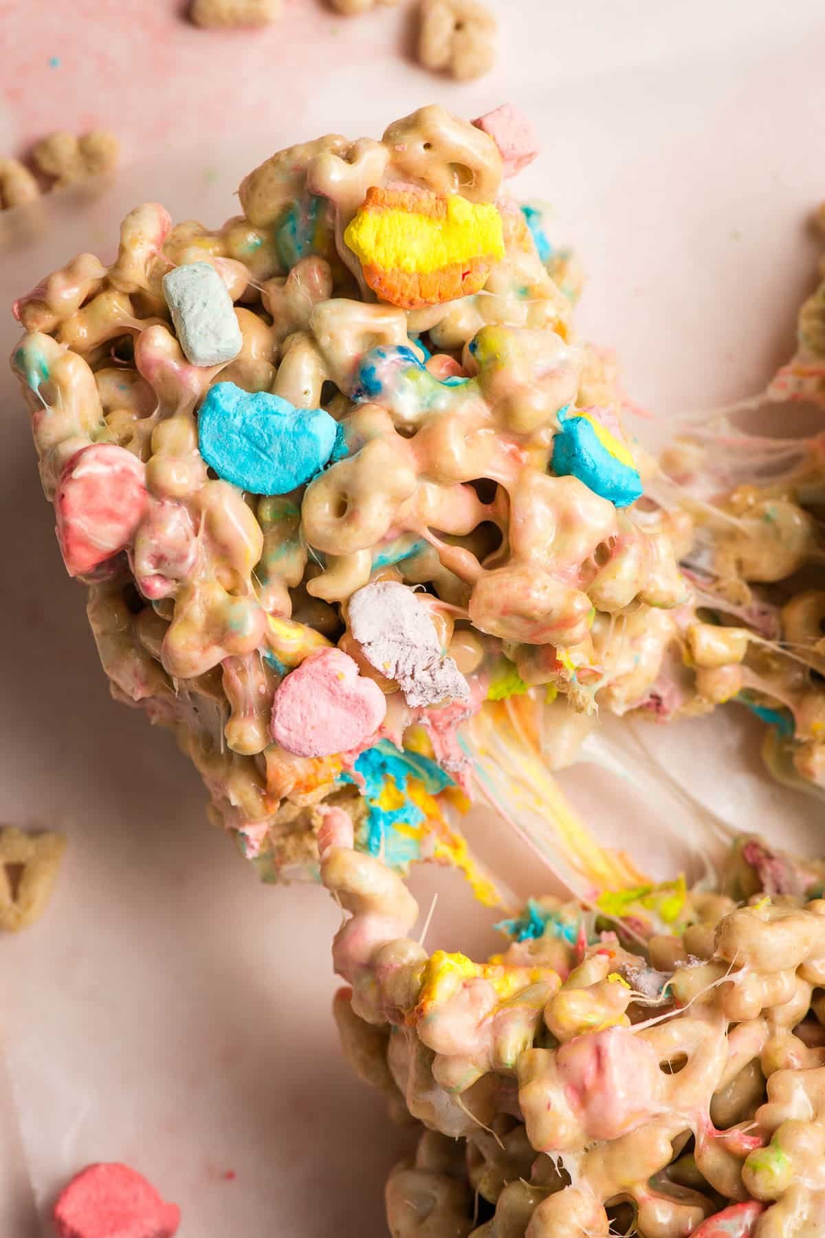 Gooey Lucky Charms Bar being pulled out of the pan.