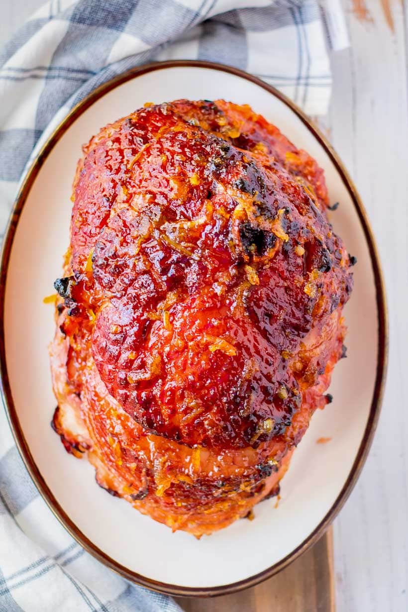 a brown sugar and honey orange glazed ham on a plate