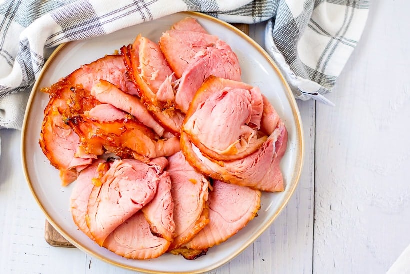 serving plate of sliced Easter ham on table with napkin
