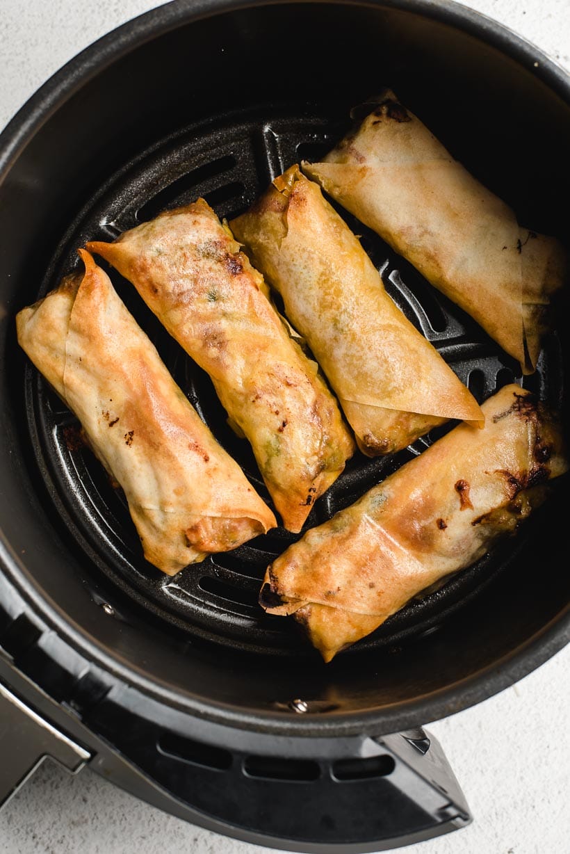 Rolled up Southwest Egg Rolls in Air Fryer after being cooked to a golden brown.