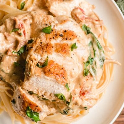 Sauteed chicken breast plated on top of sun dried tomato fettuccine.