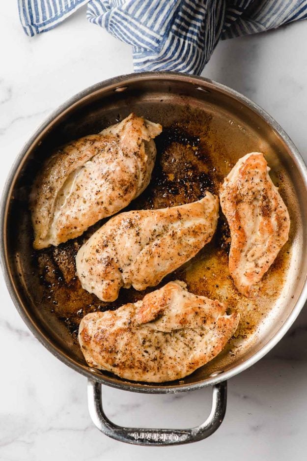Sauteed Chicken Breast in a stainless steel pan.