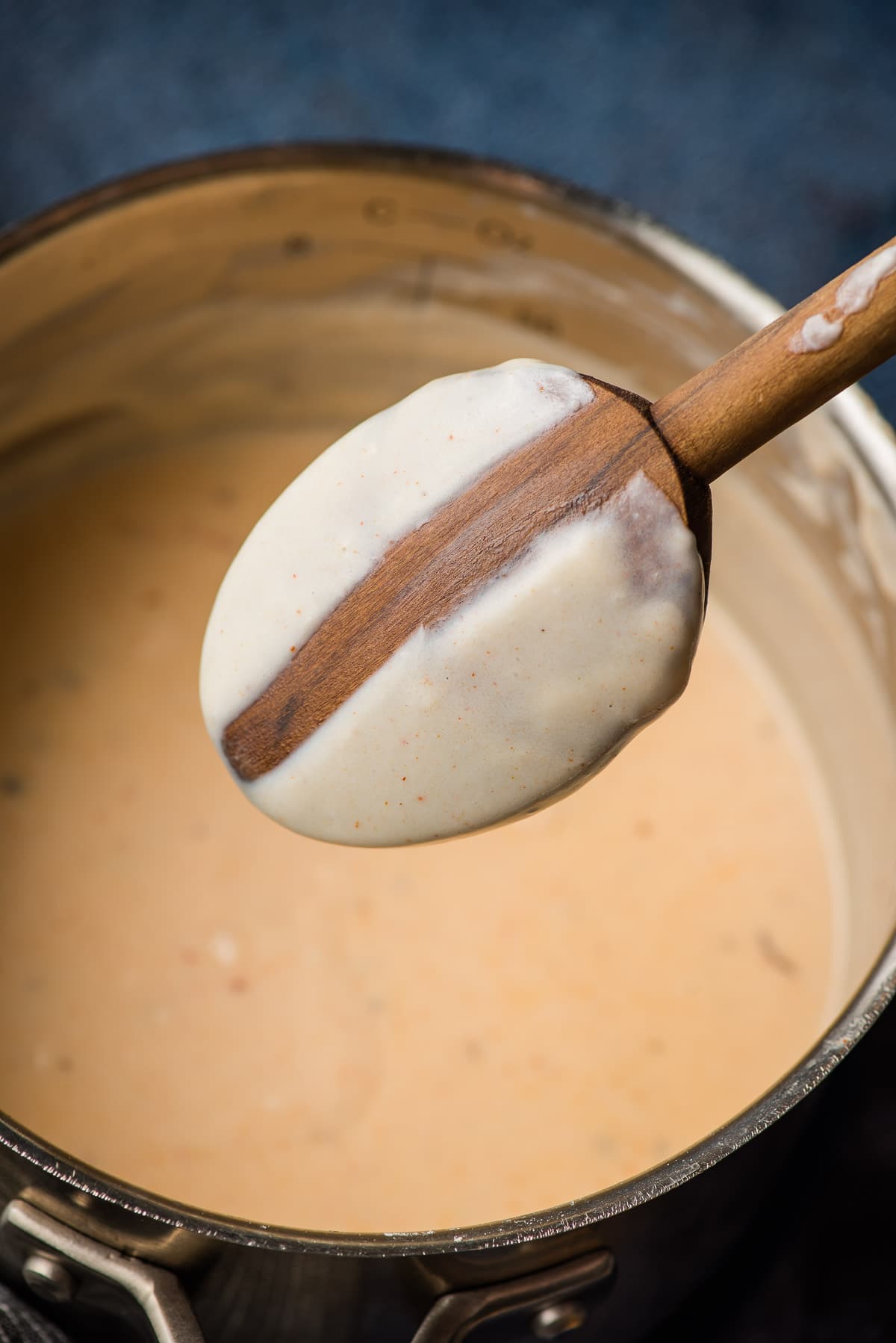 Wooden spoon dipped into a homemade roux to show the desired consistency--thick enough to coat the back of a spoon.