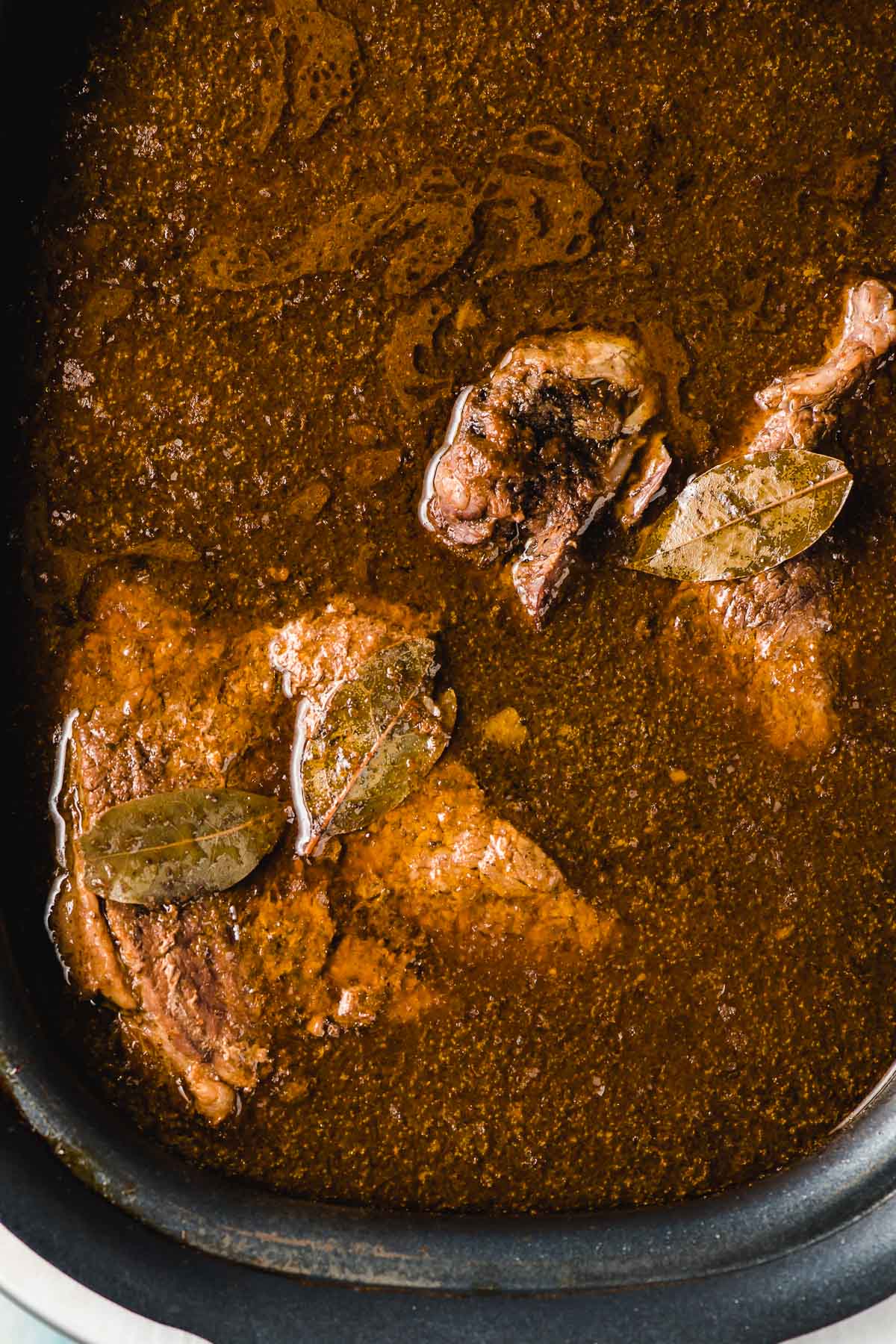 Cooked Barbacoa Beef shown in a slow cooker.