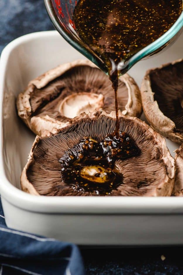 Balsamic marinade being poured onto a portobello mushroom.