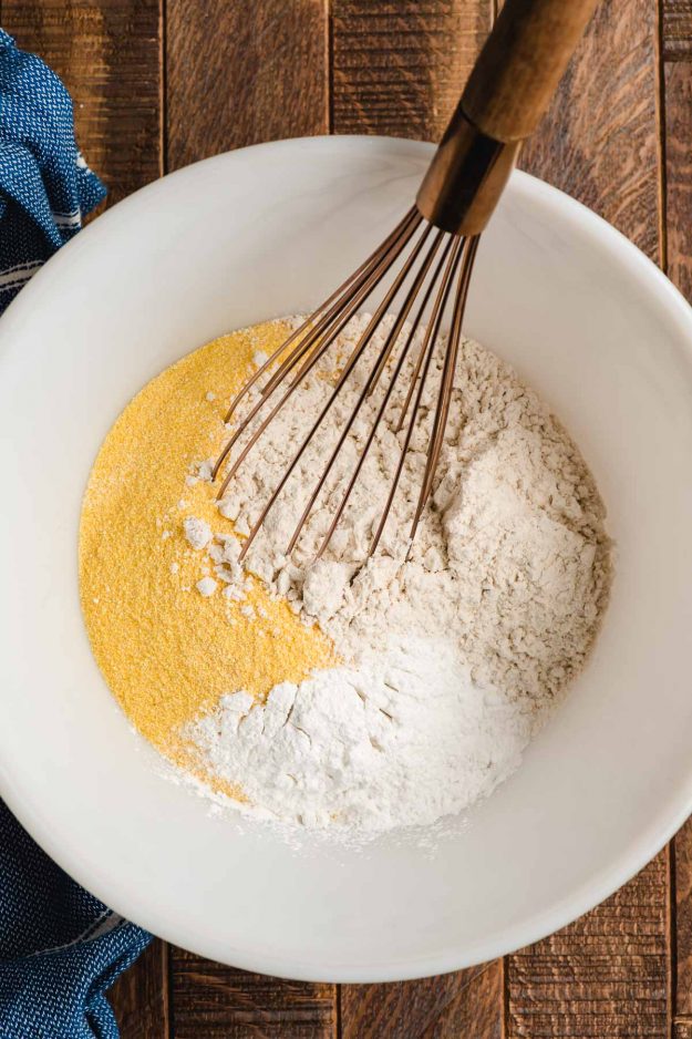 Whisk mixing together flour, baking soda, cornmeal, and salt.