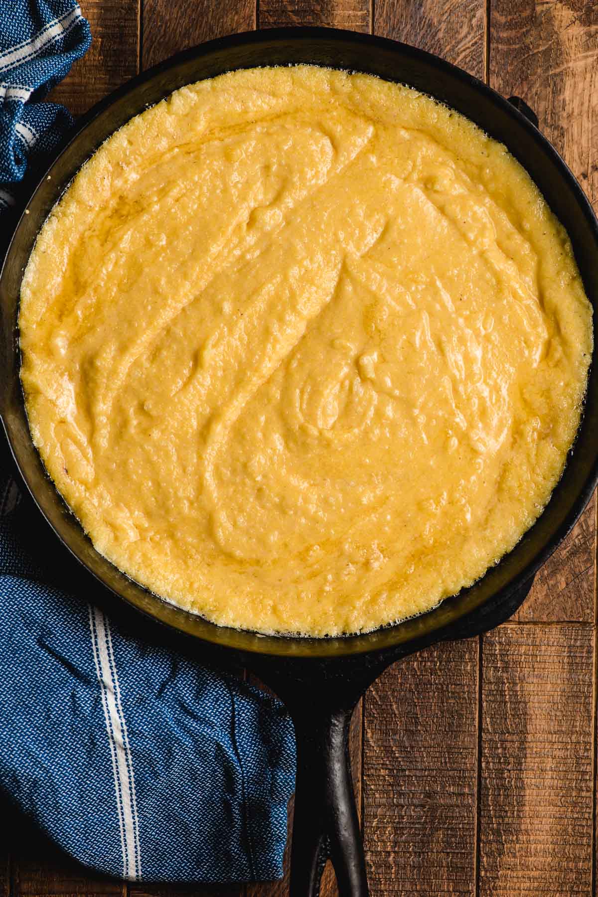 Cast iron skillet with cornbread batter in it, ready to go in the oven.