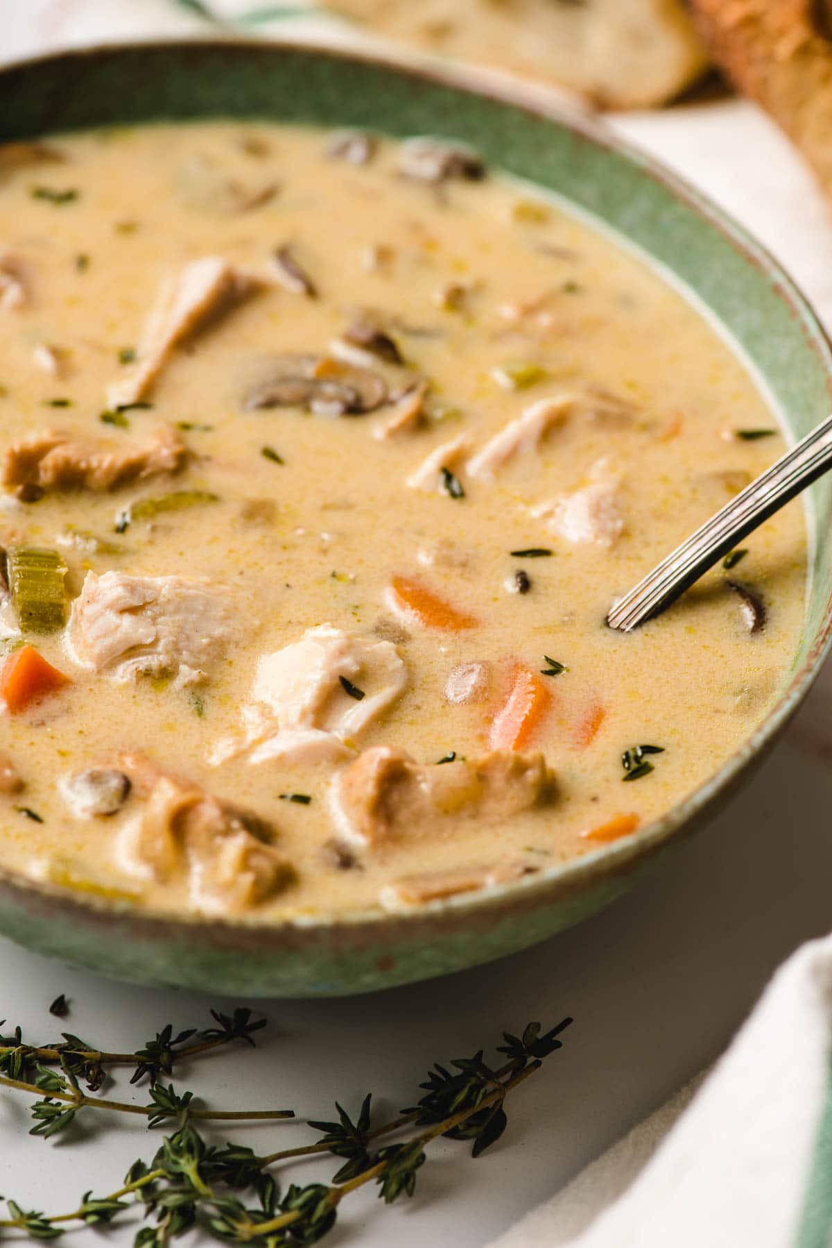 Creamy Turkey Soup in a green bowl with a spoon dunked into it.