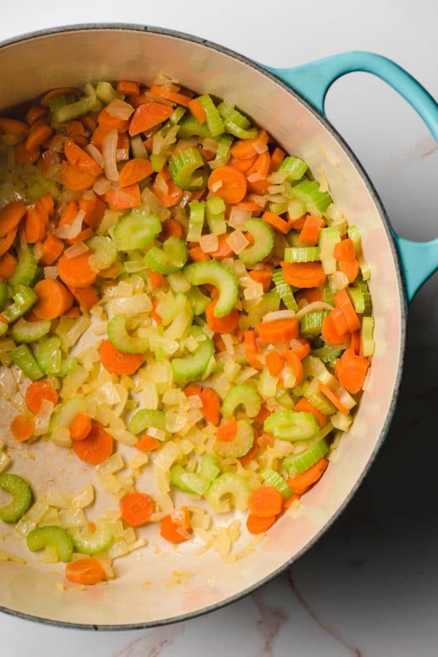 Sauteed onions, celery, and carrots in a Dutch oven.