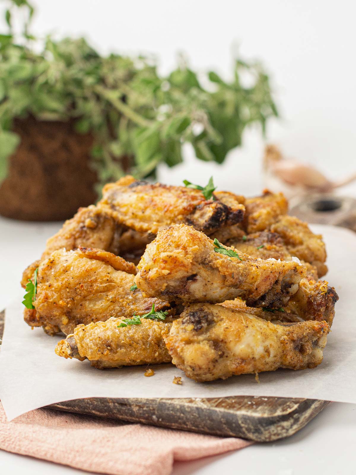 A platter of air fried chicken wings with garlic parmesan sauce.