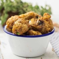 A blue rimmed white bowl filled with air fryer garlic parmesan wings.