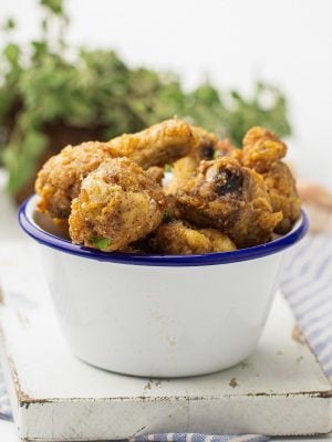 A blue rimmed white bowl filled with air fryer garlic parmesan wings.