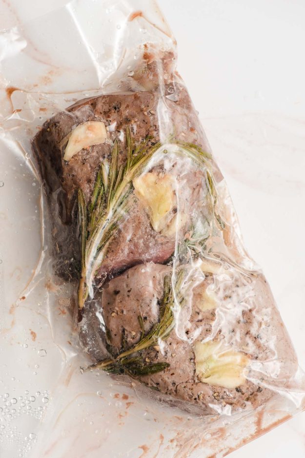 Steaks shown in a bag right after being removed from a sous vide cooker.