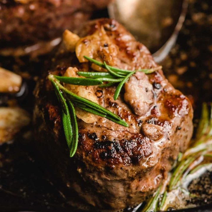 Seared filet mignon with rosemary and garlic on top.