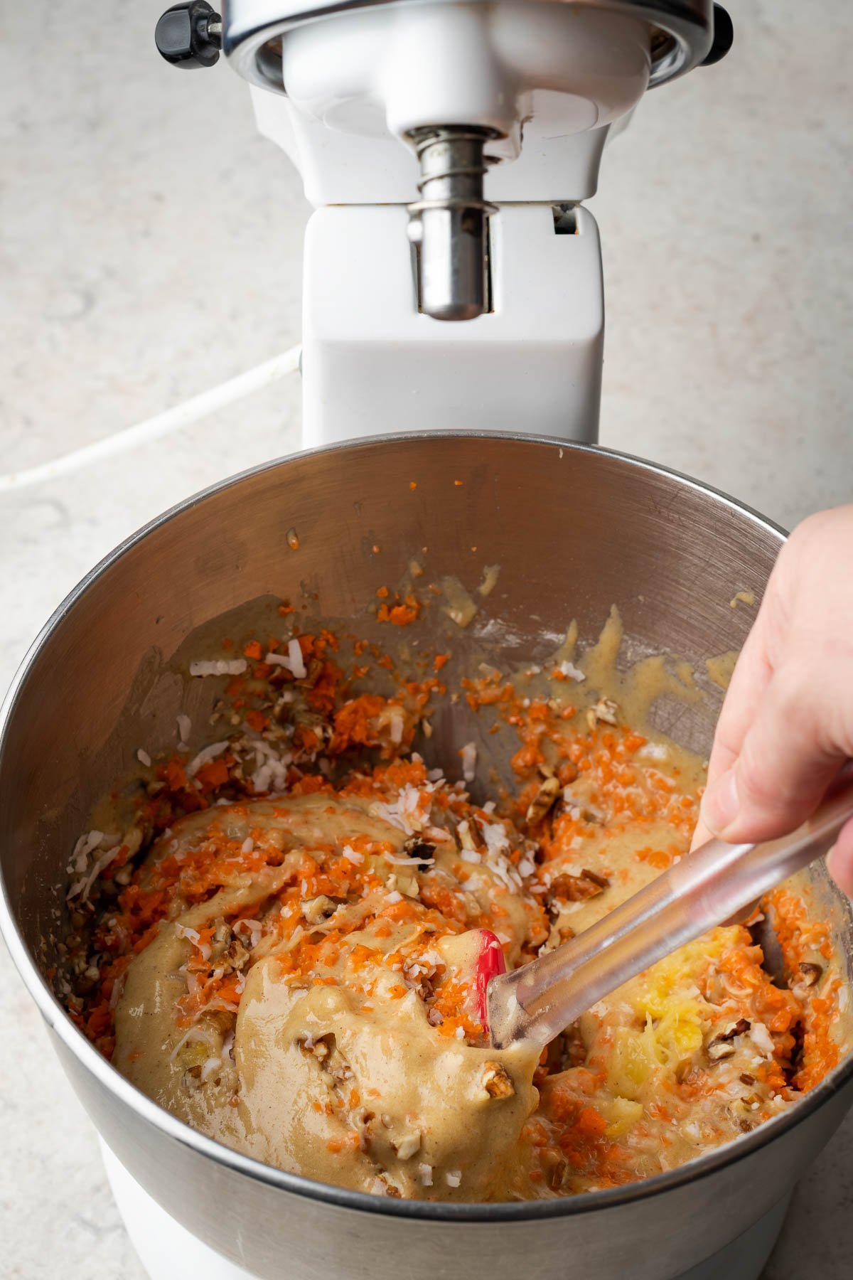 Mixing grated carrots into cake batter.