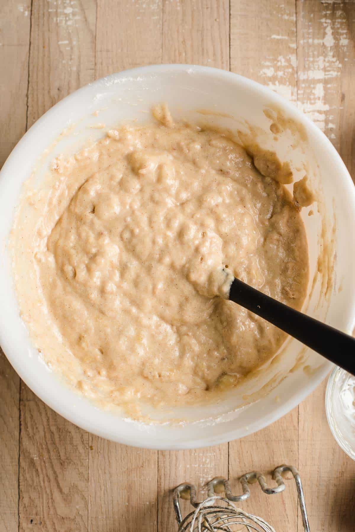 White mixing bowl with banana bread batter.