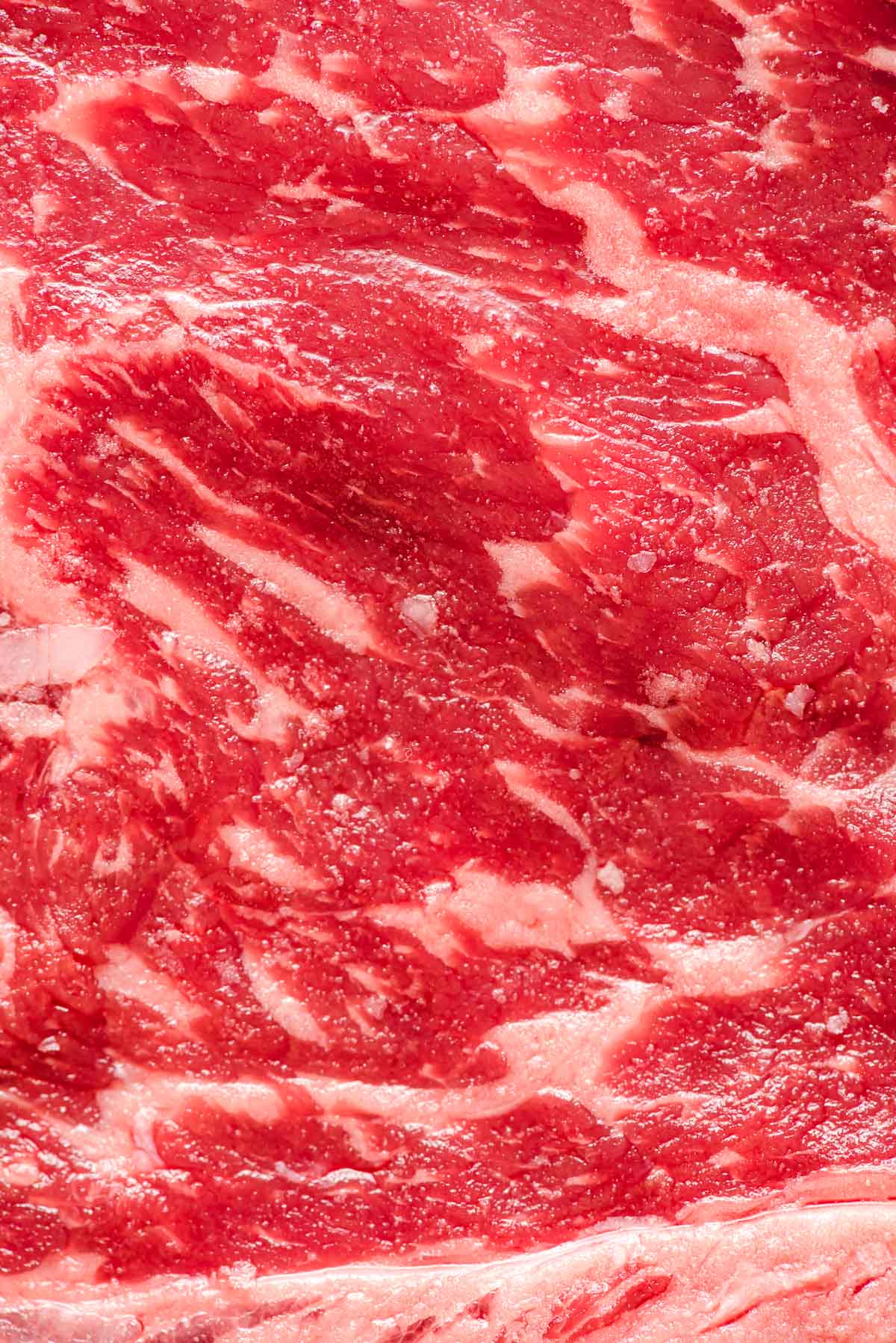 Closeup of a steak shows marbling.