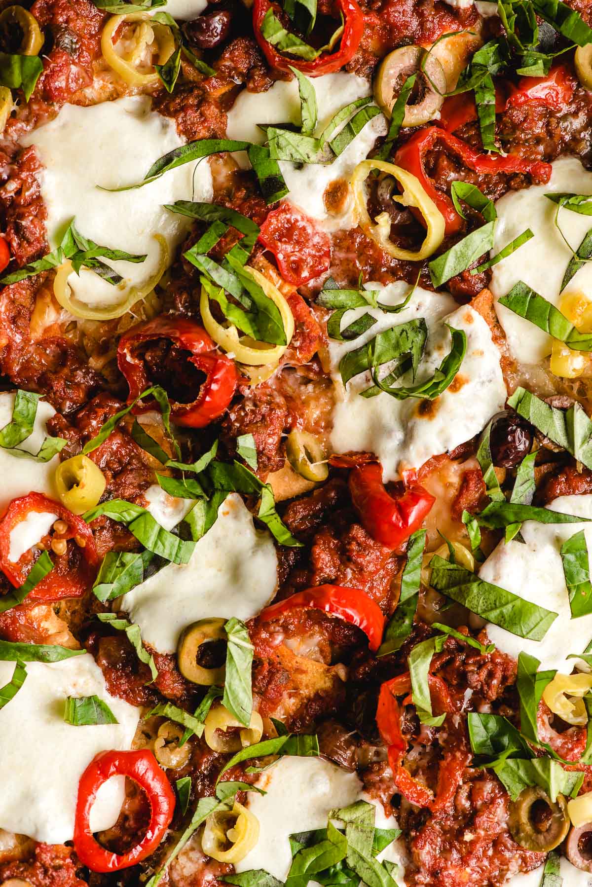 Italian Nachos with basil, mozzarella, banana peppers, and olives.