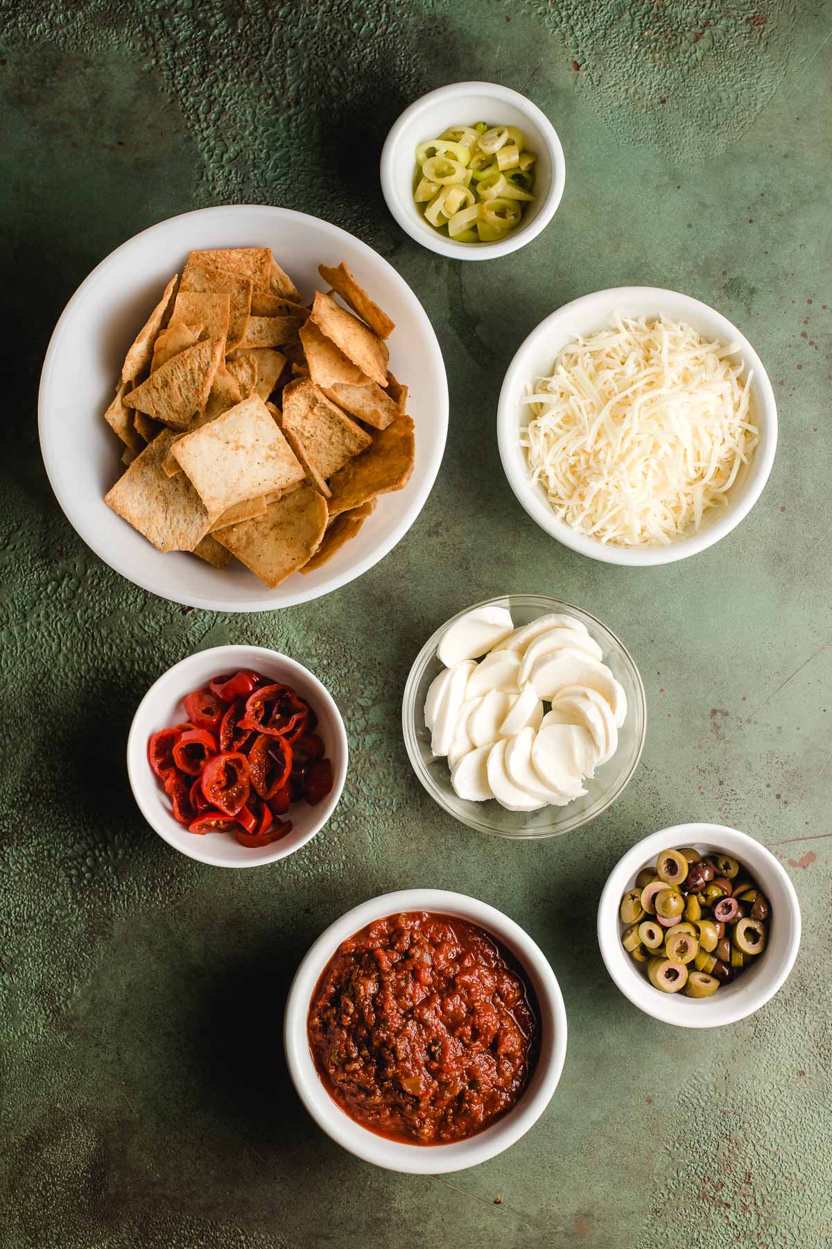 Ingredients for Italian Nachos displayed in white bowls.