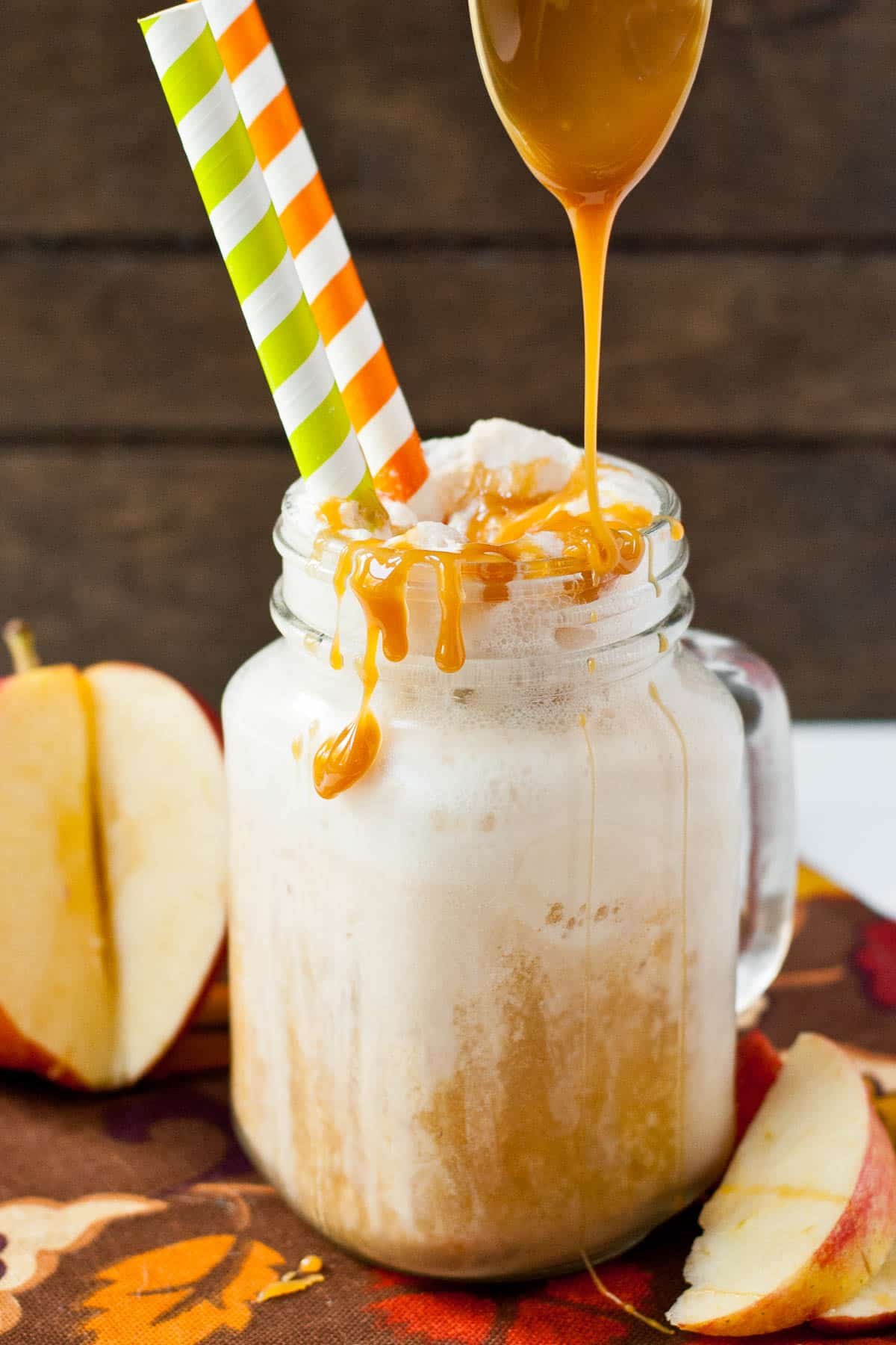 Spoon of caramel dripping over an apple cider float.