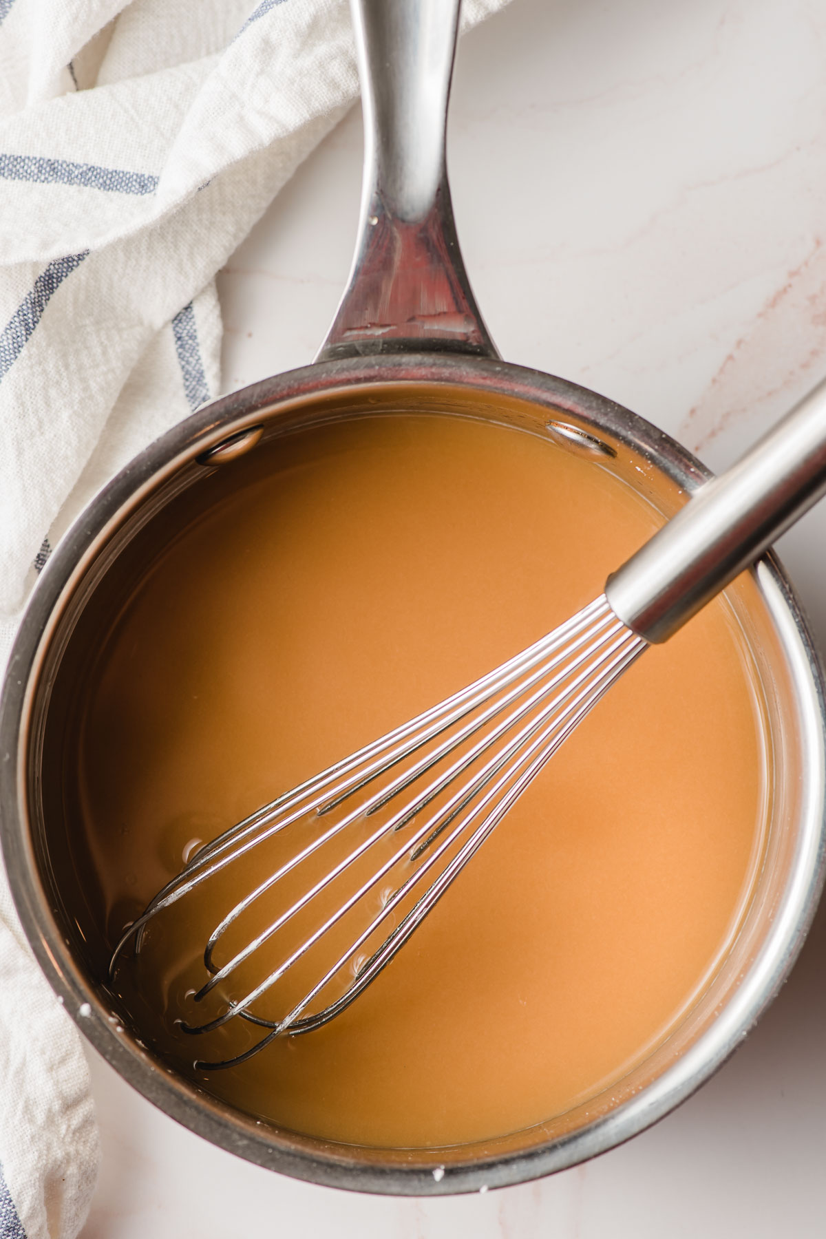 Apple cider, cornstarch, and brown suagr in a saucepan with a whisk.
