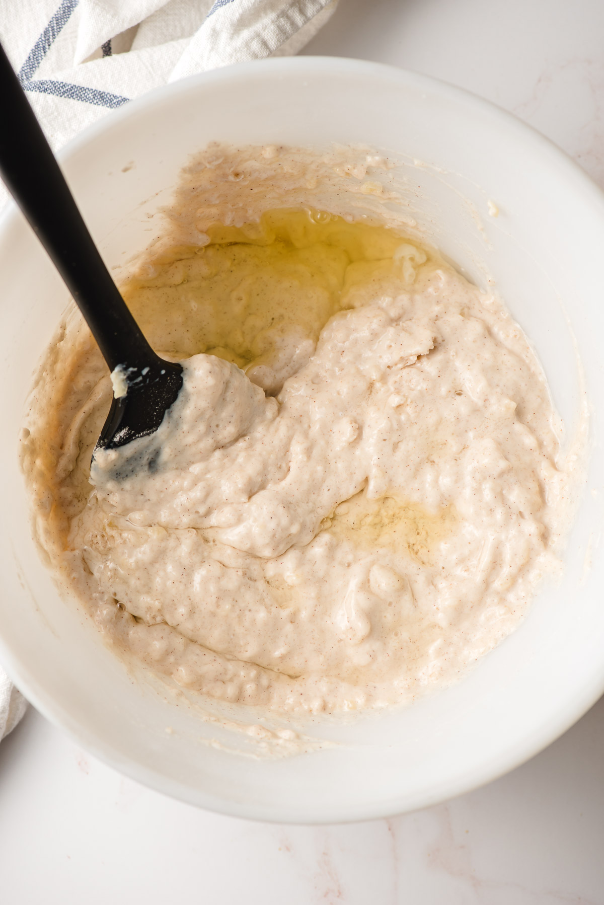 Spatula stirring egg white into pancake batter.