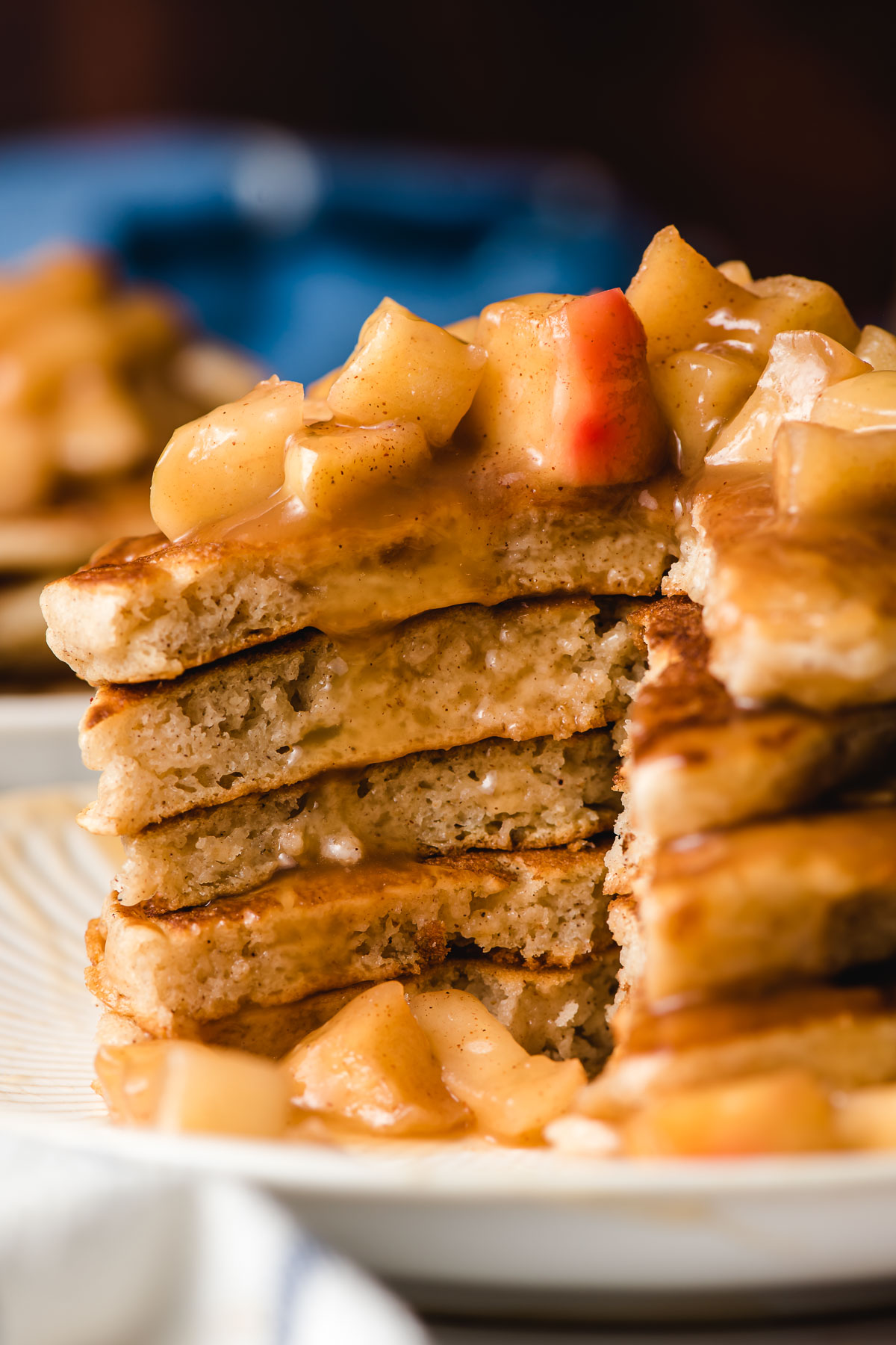 Stack of cinnamon pancakes with apples on top.
