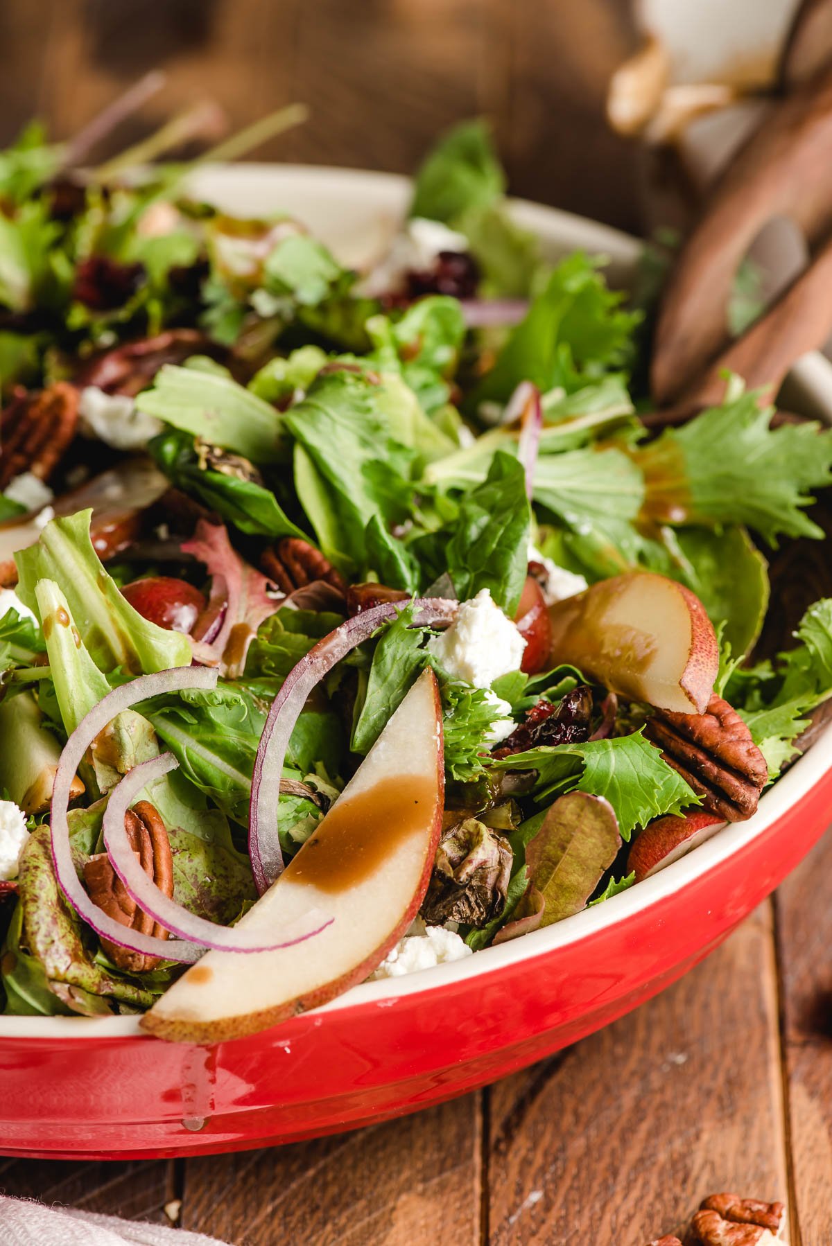 Salad with pear slices, red onion, and maple vinaigrette.