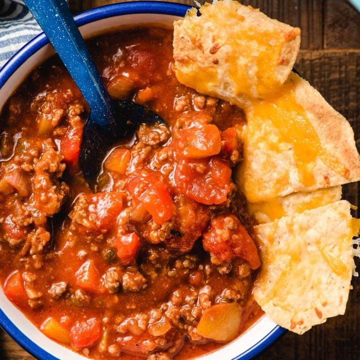 A bowl of Italian Sausage Chili with cheesy chips.