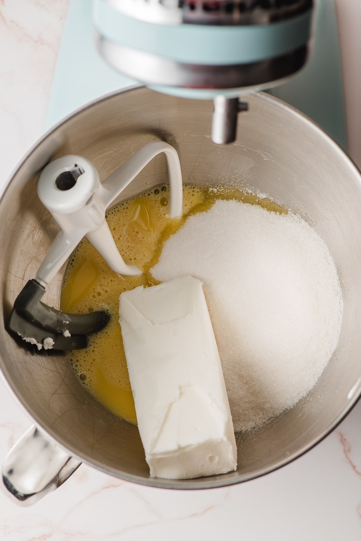 Shortening, sugar, and eggs in the bowl of an electric mixer.