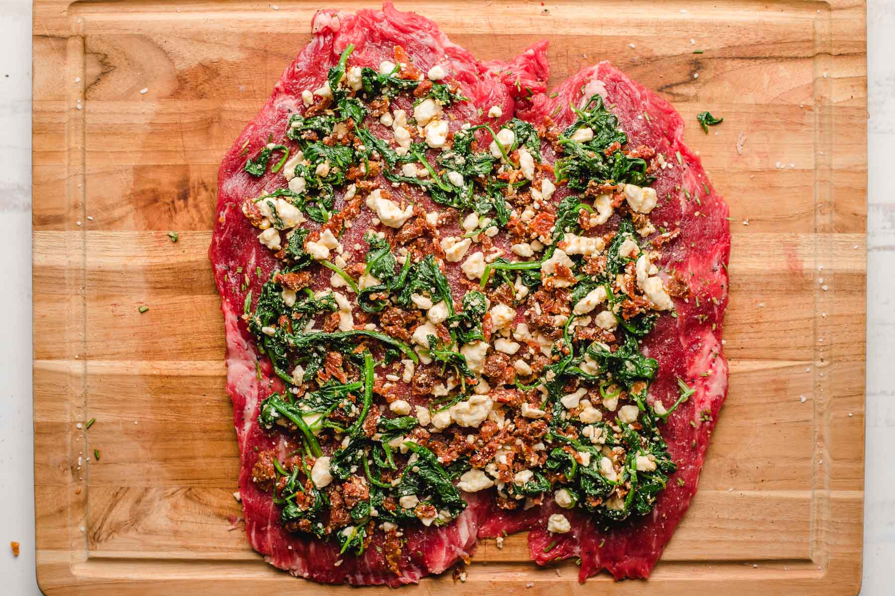 Flank steak butterflied and topped with sauteed spinach, feta, and sun dried tomatoes.
