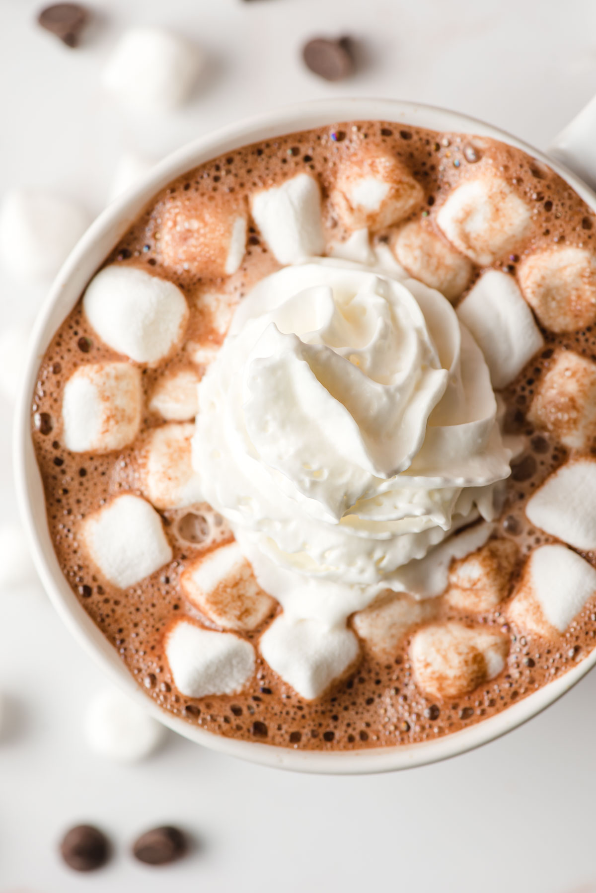Top down image of hot chocote topped with whipped cream and marshmallows.