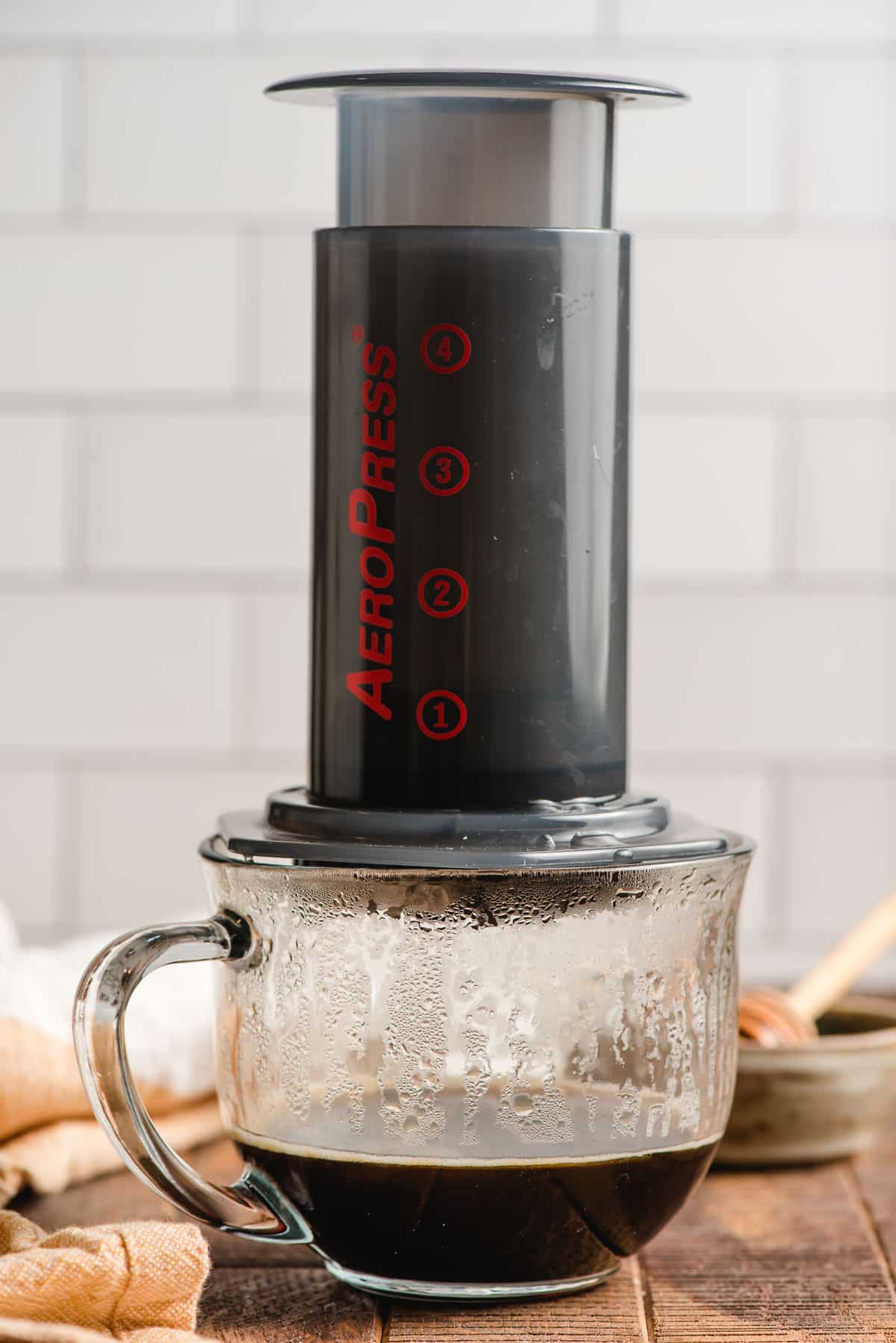 Aeropress pressing coffee into a glass mug.
