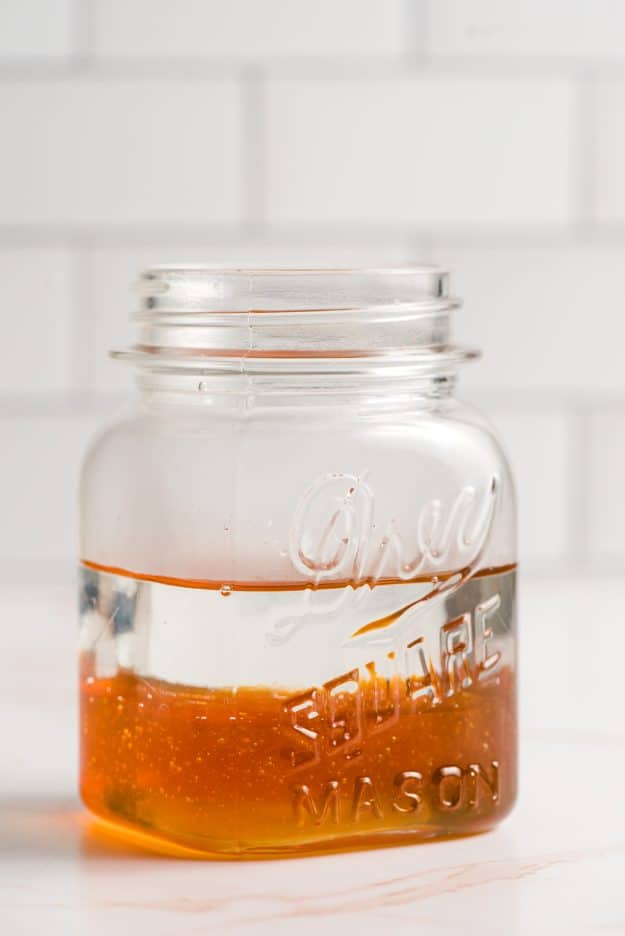 Water and honey layered in a glass jar.