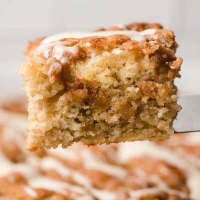 Slice of banana crumble cake on a metal spatula.