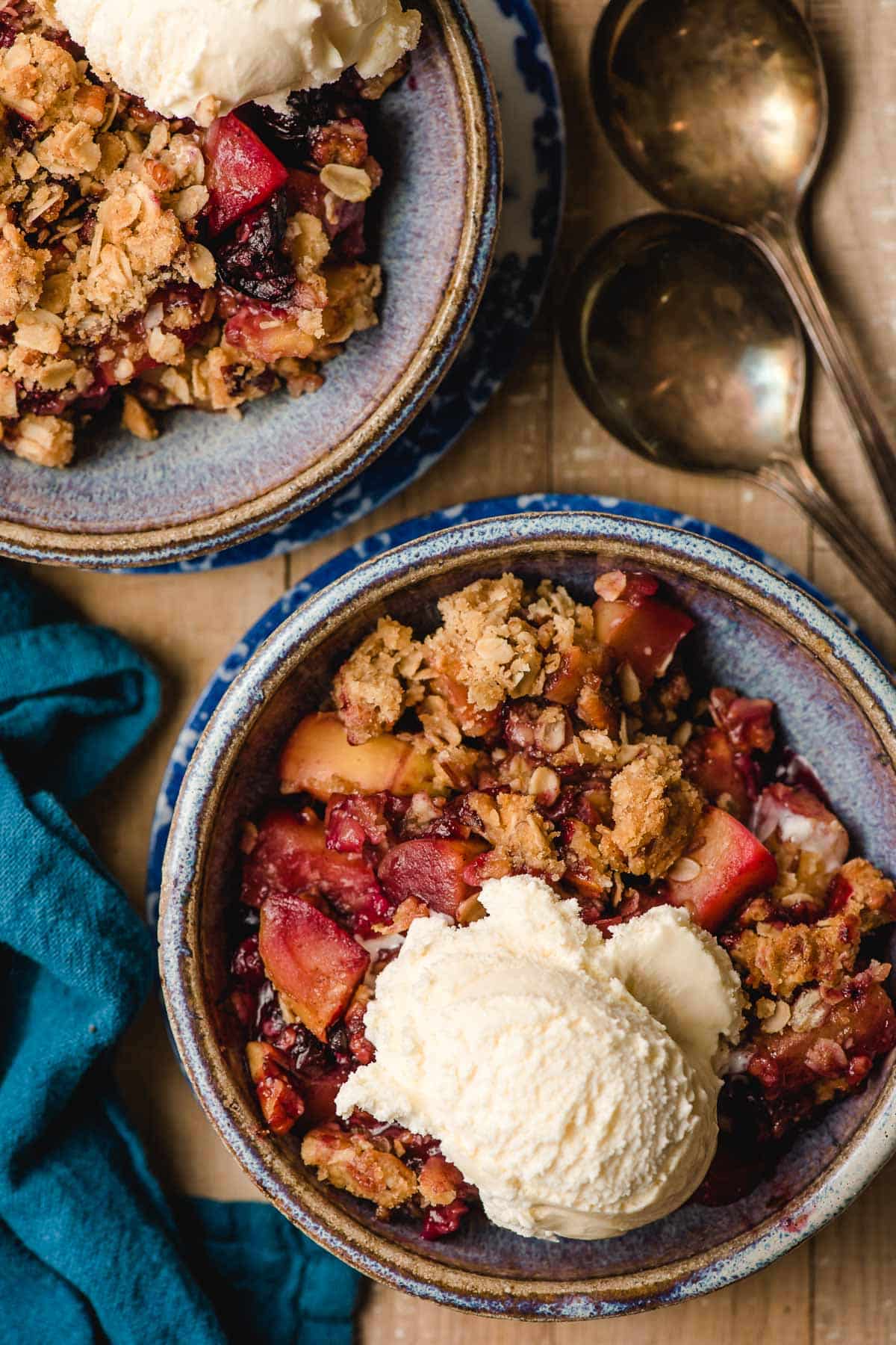 Scoop of ice cream atop a serving of apple blueberry crumble.