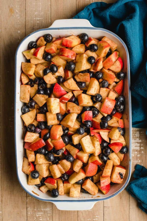 Casserole dish filled with apple and blueberry mixture.