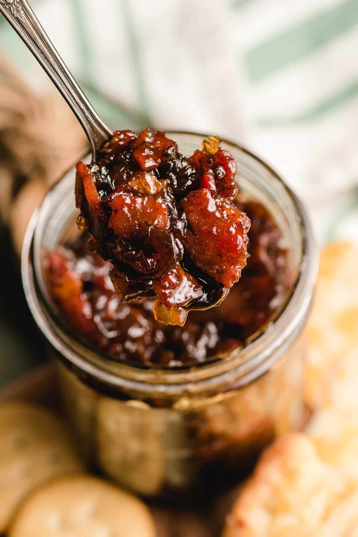 Spoon scooping bacon onion jam out of a jar.