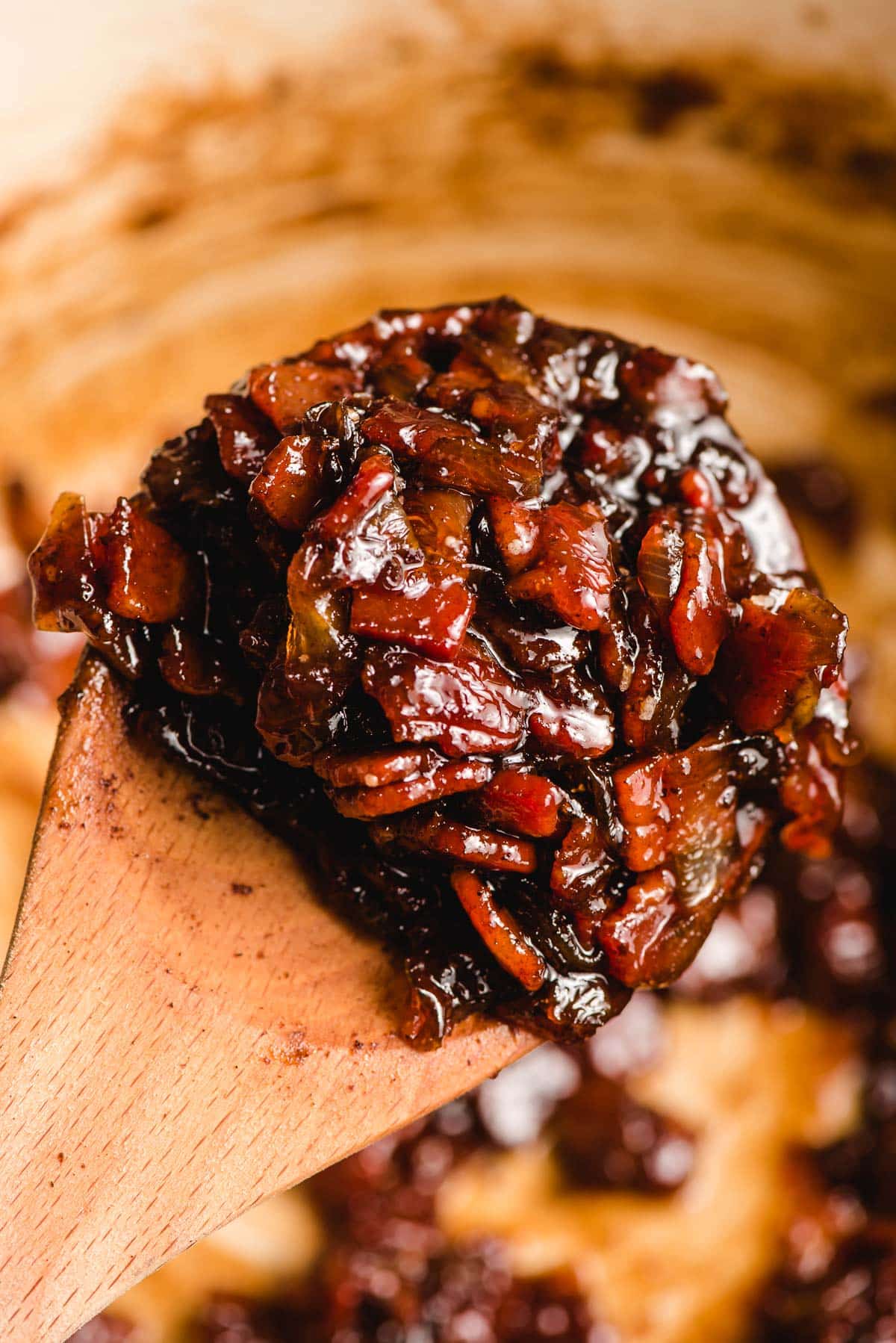 Jam with bacon, onions, and bourbon on a wooden spoon.