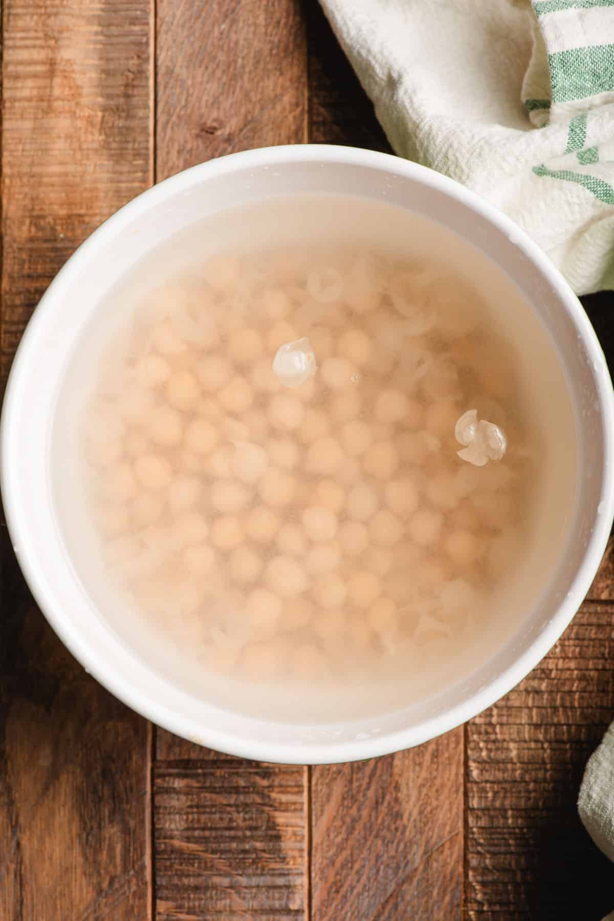 Chickpeas soaking in a bowl.