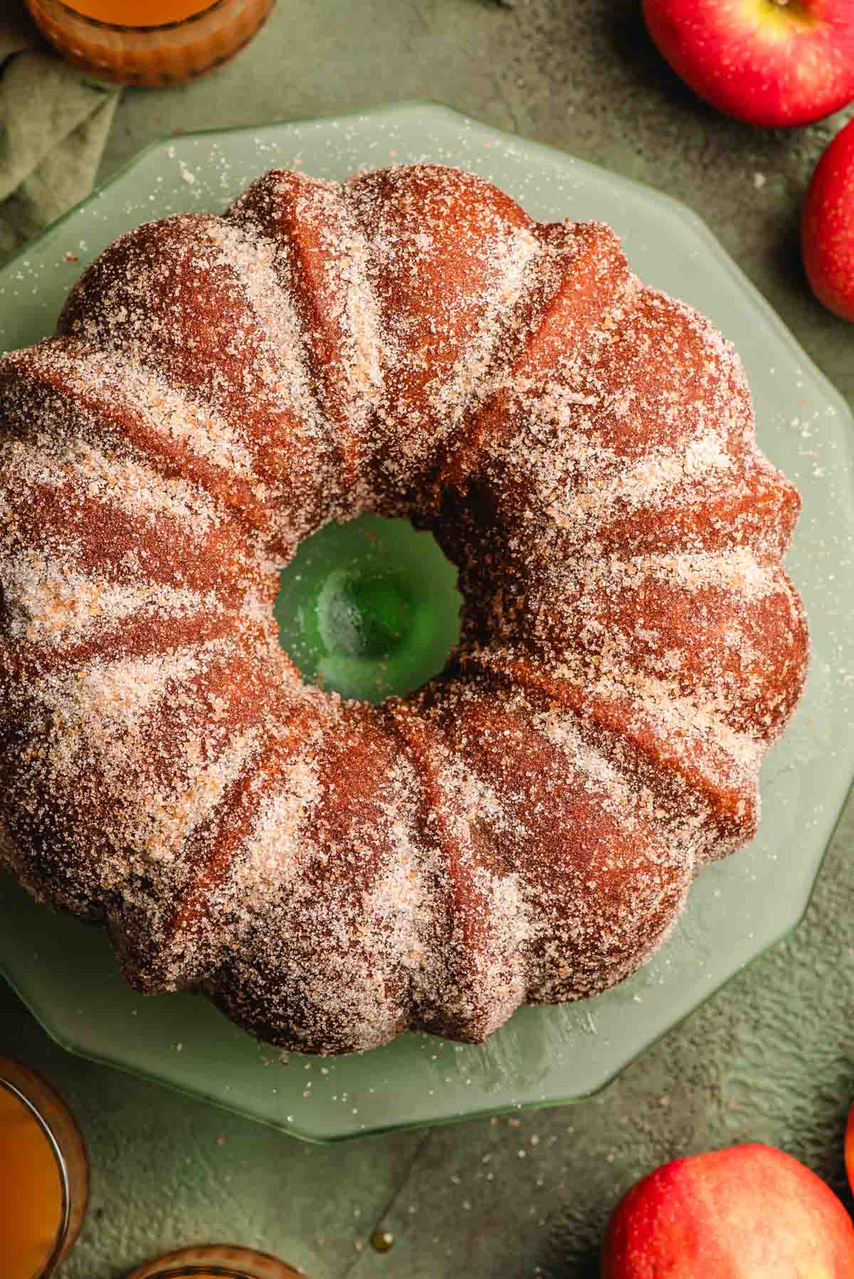 Overhead view of an apple cider bundt cake topped with cinnamon and sugar.