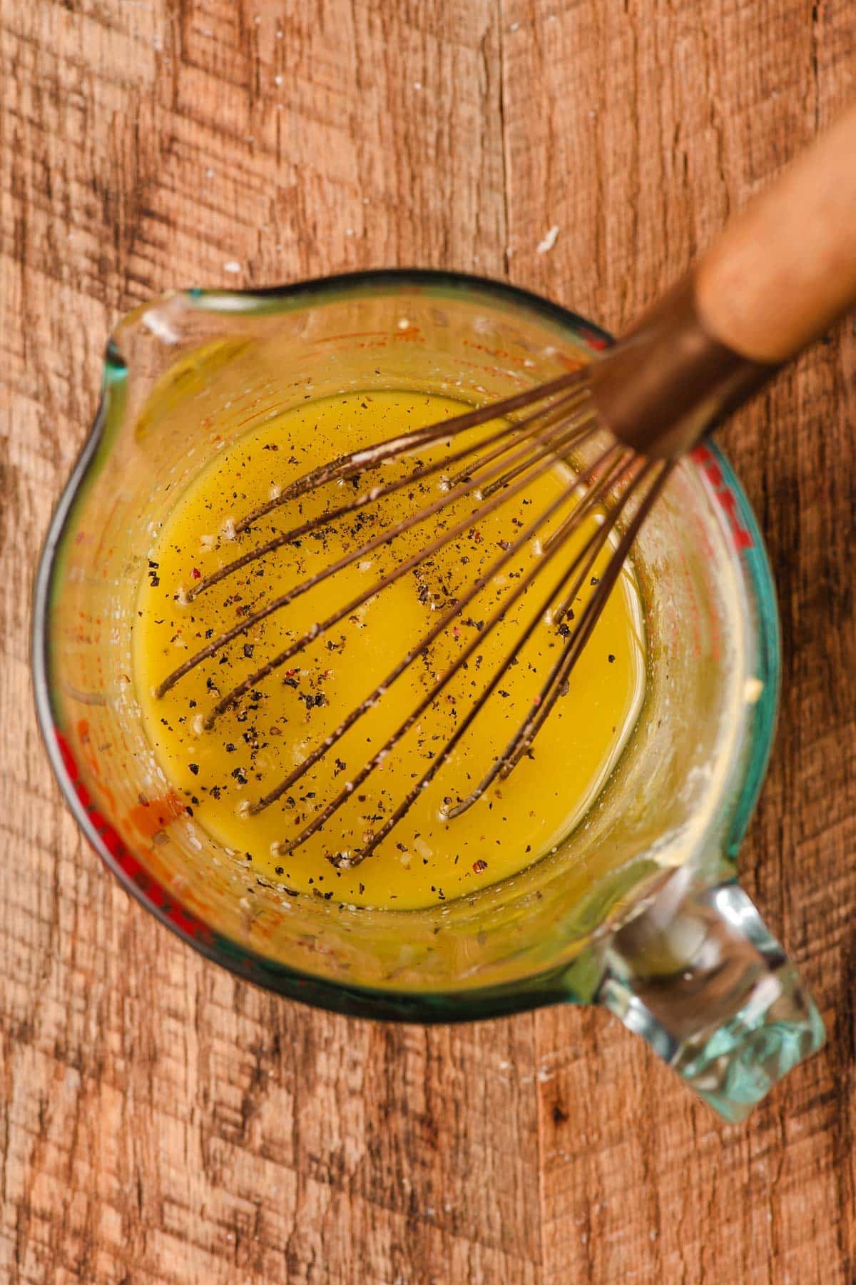 Mustard vinaigrette whisked in a glass measuring cup.