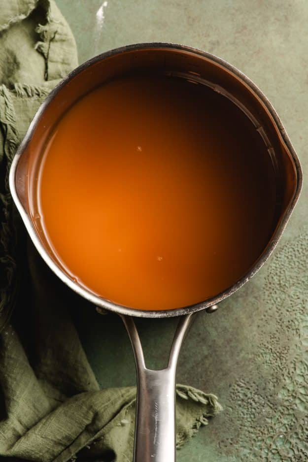 Apple cider in a small sauce pan, showed before being reduced.